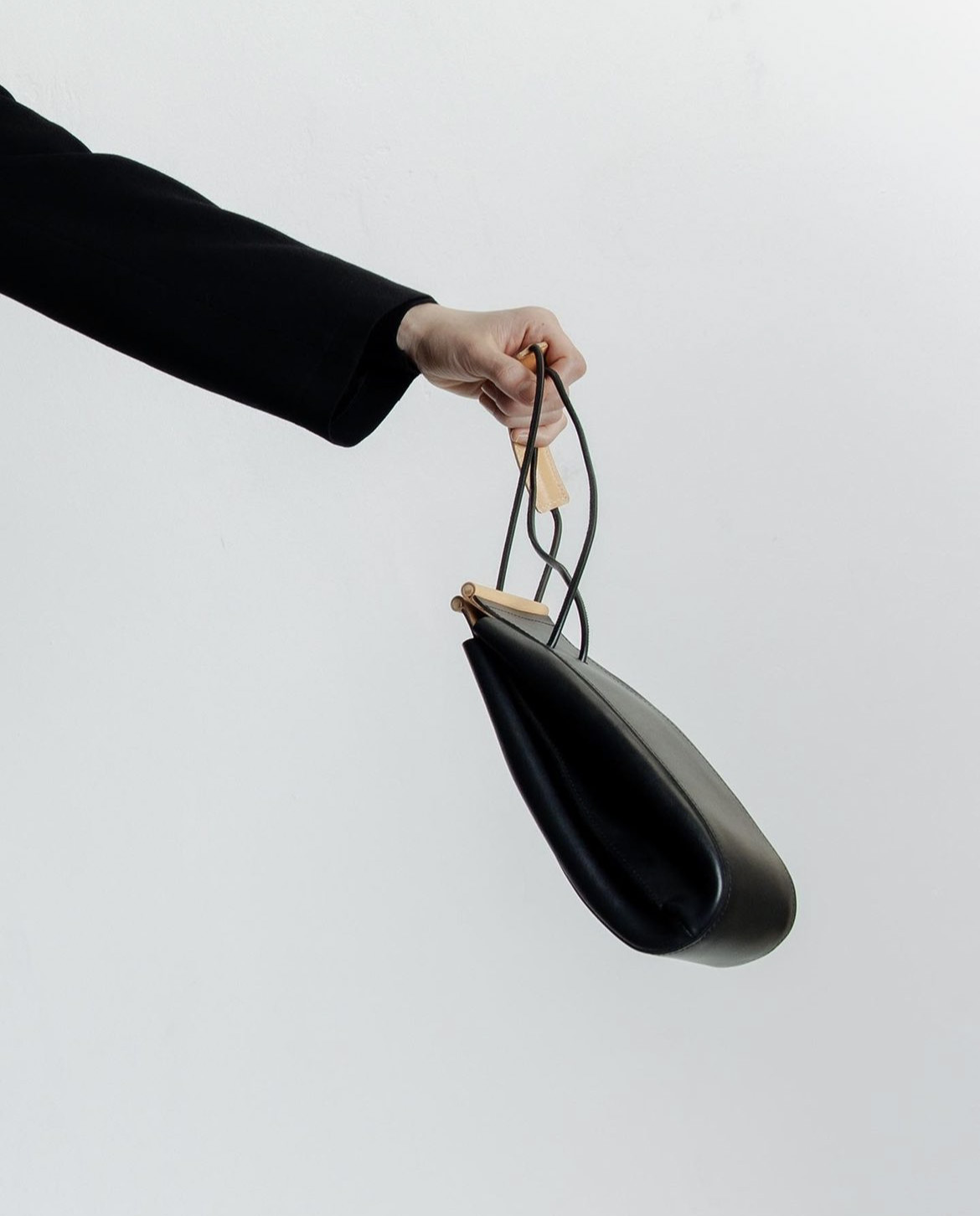 a hand carrying nowhow studio handbag.
