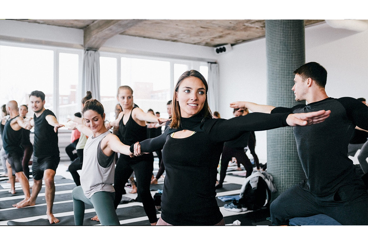 A group of yoga enthusiasts practicing yoga in a spacious studio at RAW Studios, Berlin