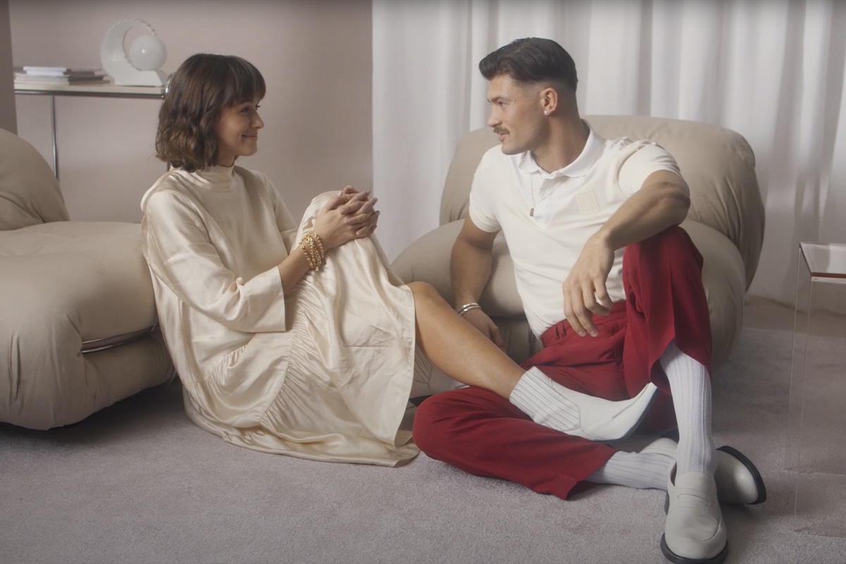 A Caucasian couple in a pink studio setting, featured in a VOGUE Germany x Tiffany collaboration video titled 'The Look of Modern Love.