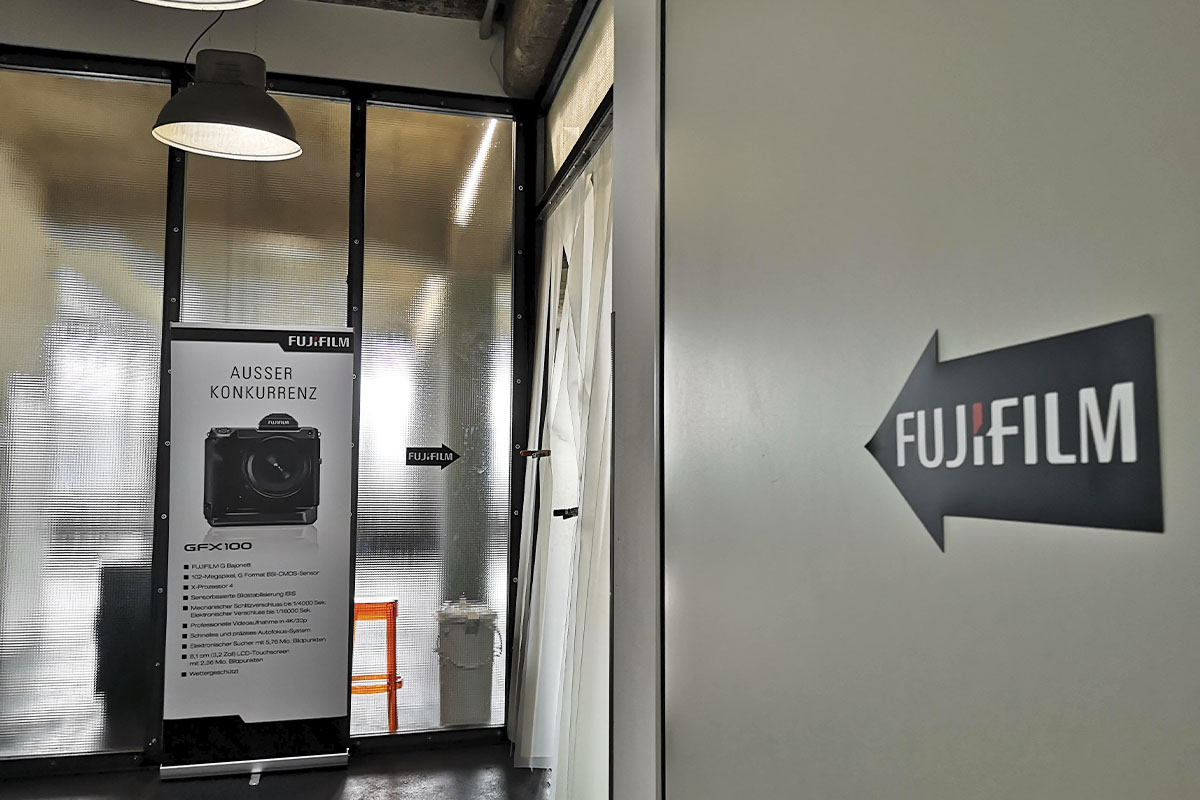 The entrance of raw studios., featuring a Fujifilm GFX100 promotional stand directing visitors at the Fuji Road Show event.